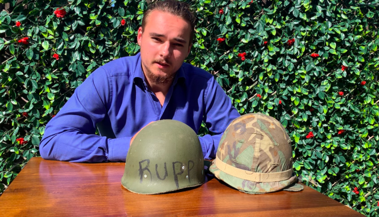 Hugo Booth sitting at a table with Jeffrey David Rupp's helmet and the helmet insert