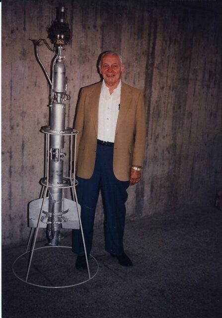 Konrad Dannenbery standing beside an R-7 rocket.