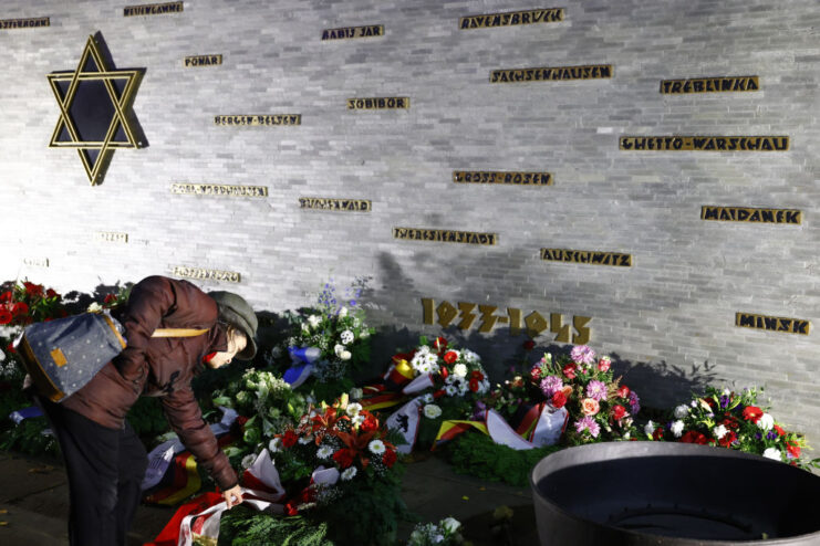 Woman laying flowers at the Remembrance Wall of the Berlin Jewish Community Center