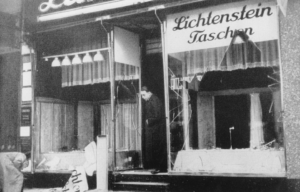 Woman standing at the entrance of a store that has had its front windows smashed