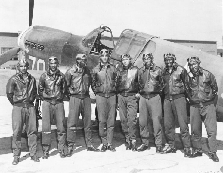 Eight Tuskegee Airmen standing in front of a Curtiss P-40 Warhawk