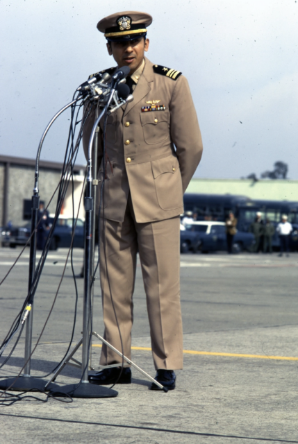 Everett Alvarez, Jr. standing before a microphone