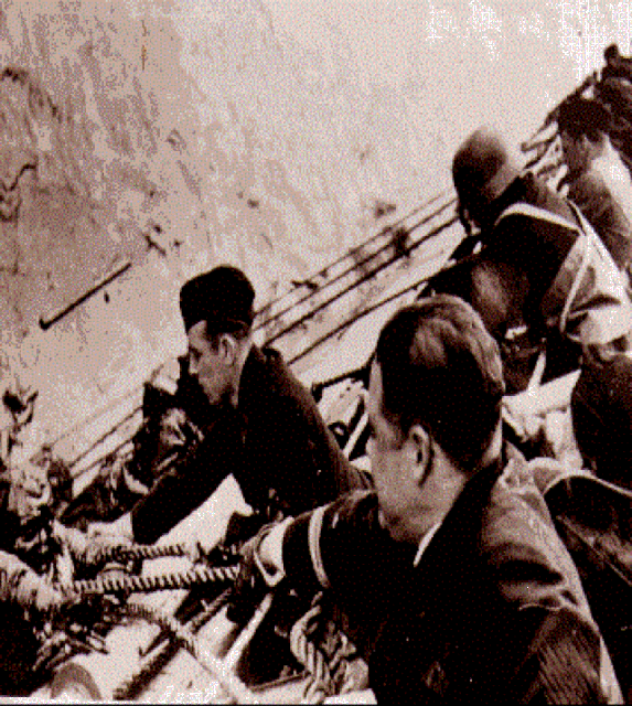 German sailors reaching over the side of Admiral Hipper to rescue British sailors from the North Sea