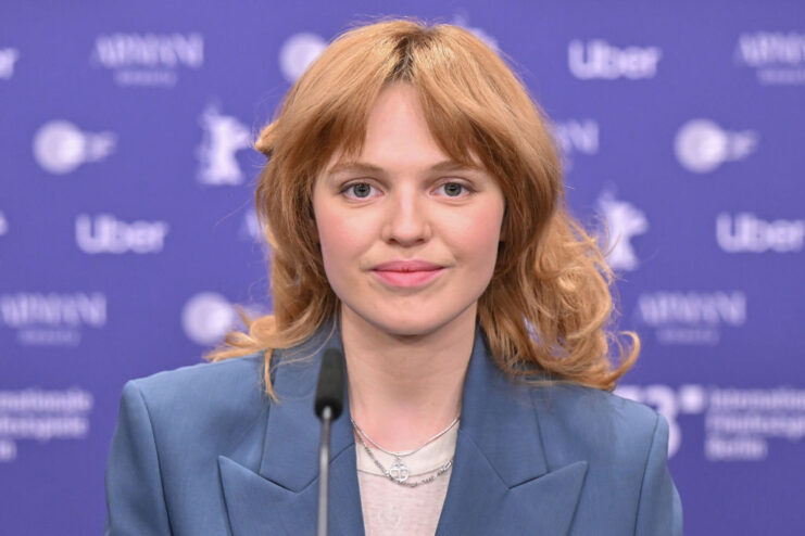 Odessa Young sitting at a microphone