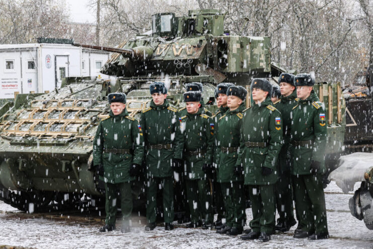 Group of Russian soldiers standing next to an M2 Bradley