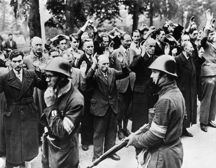 Dutch soldiers standing watch over suspected collaborators