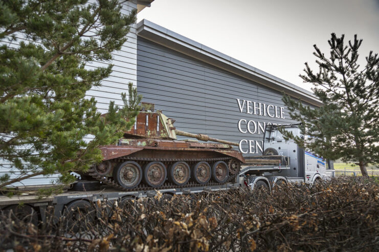 Charioteer on the flatbed of a truck, parked outside a building